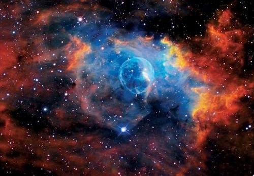 這是著名的“氣泡星云”（Bubble Nebula），這是一個(gè)灰塵氣體星云，其直徑為10光年，相當(dāng)于60萬(wàn)億英里。氣泡星云是由一顆恒星燃燒時(shí)的脫離物質(zhì)構(gòu)成，恒星燃燒時(shí)可釋放出太陽(yáng)數(shù)百倍亮度的光芒。該星云距離地球11000光年，位于仙后星座。