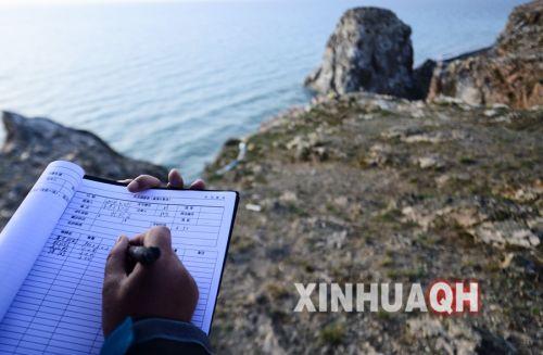青海湖國家級自然保護區(qū)管理局工作人員在記錄鳥類觀測數(shù)據(jù)。新華社　張宏祥　攝