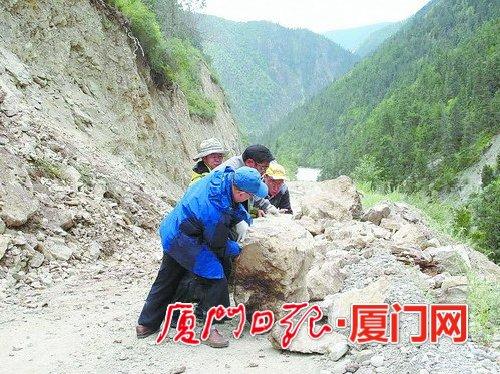 援藏干部下鄉(xiāng)調(diào)研途中遇到滾石墜落，合力將滾石推開為汽車開道。（肖衛(wèi)東 供圖）