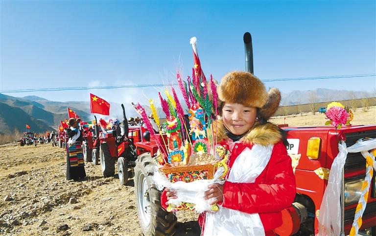 圖為拉薩市達(dá)孜縣塔杰鄉(xiāng)巴嘎雪村11歲的白瑪?shù)录淮謇镞x定為今年開耕儀式上撒第一粒種子和端切瑪?shù)娜?。記?旦增 攝