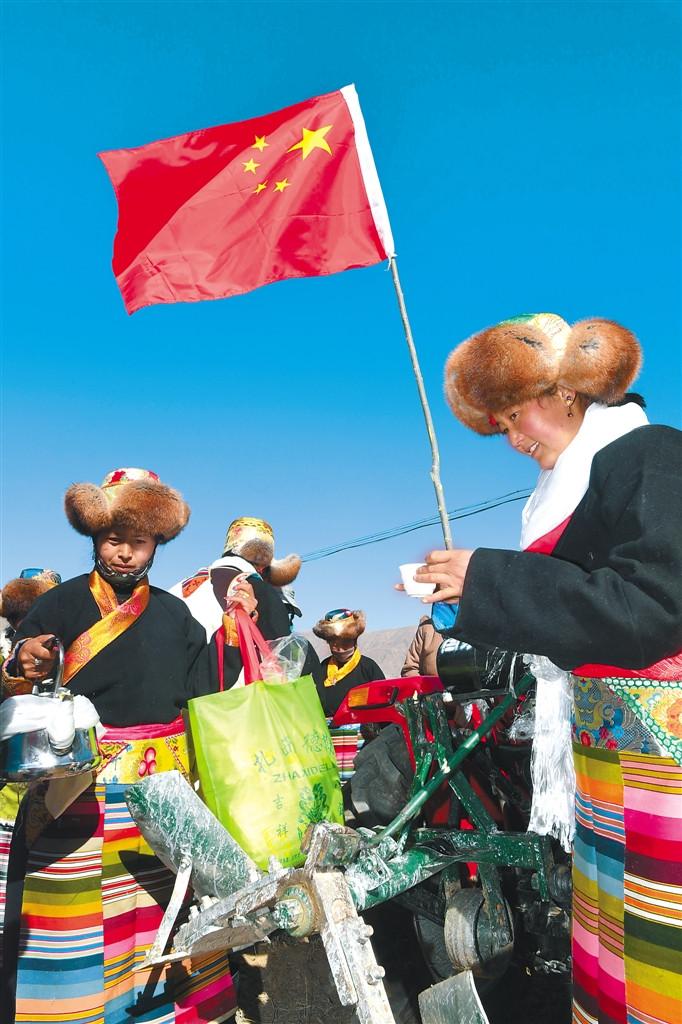 圖為拉薩市達(dá)孜縣塔杰鄉(xiāng)巴嘎雪村三組開耕儀式結(jié)束后，在鮮艷的紅旗下村民們互敬香醇的青稞酒，祝福美好生活。 記者 旦增 攝
