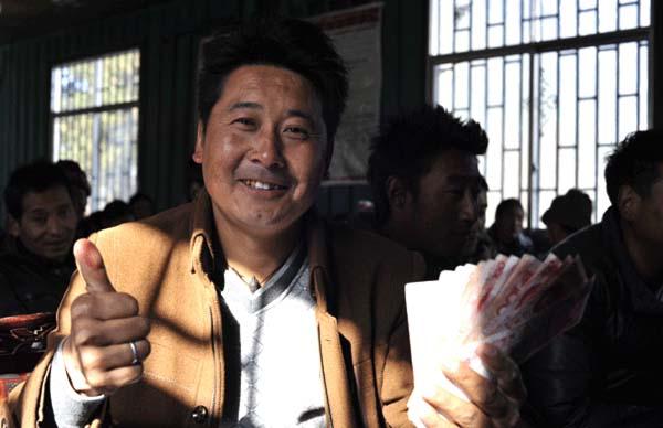 崗巴村一村民領(lǐng)到生態(tài)補(bǔ)償金后，豎起大拇指夸贊黨和國(guó)家的生態(tài)環(huán)保政策 本報(bào)記者 麥正偉 攝.jpg