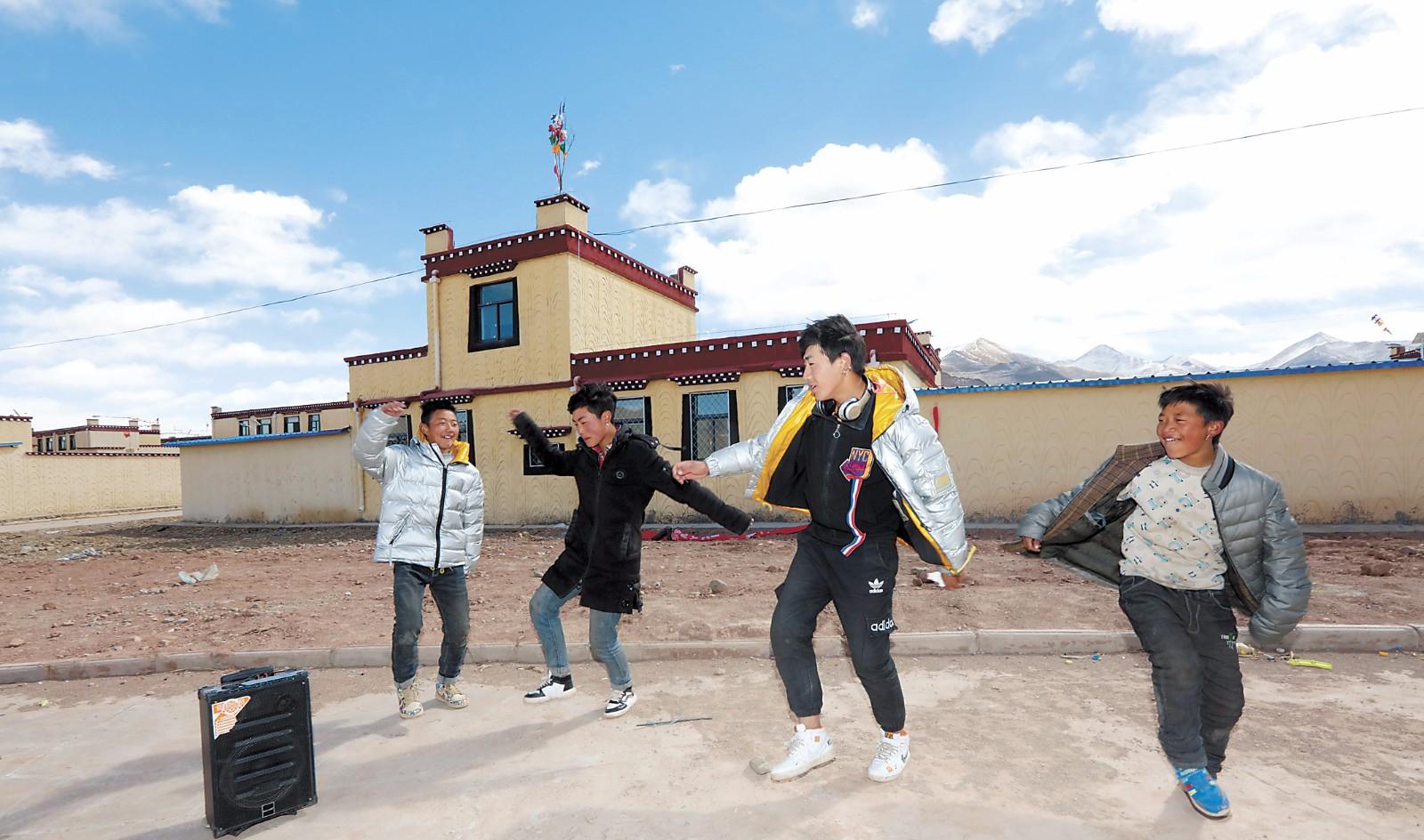 拉薩市林周縣卡孜鄉(xiāng)“三巖”片區(qū)精準(zhǔn)扶貧集中搬遷點的群眾在新房前跳舞。記者 次旺 洛桑 攝