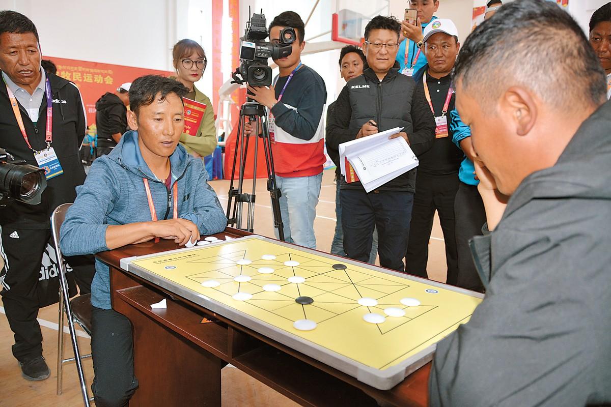 一張小小的棋桌上，兩名對手屏氣凝神，黑白棋子廝殺較量。這是本屆農(nóng)牧民運動會藏棋項目比賽的情景。