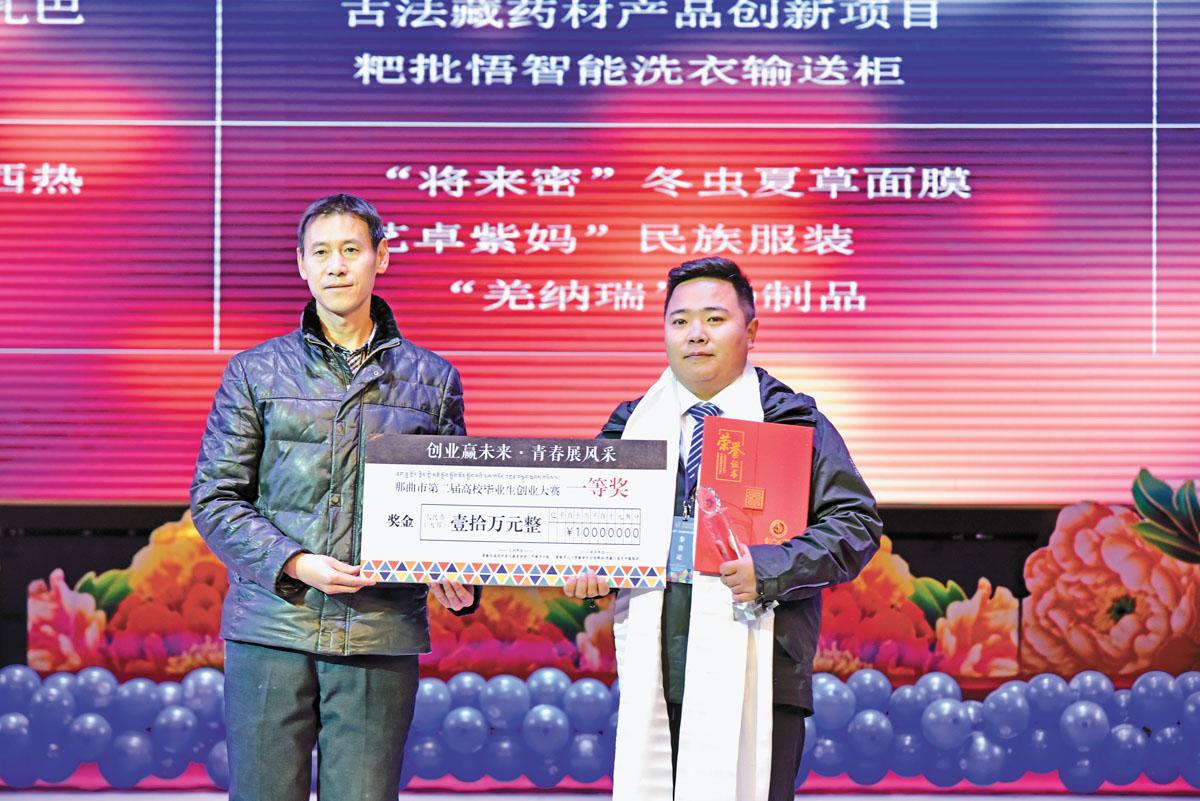 圖為那曲市副市長母興斌（左）為一等獎(jiǎng)選手頒獎(jiǎng)。
