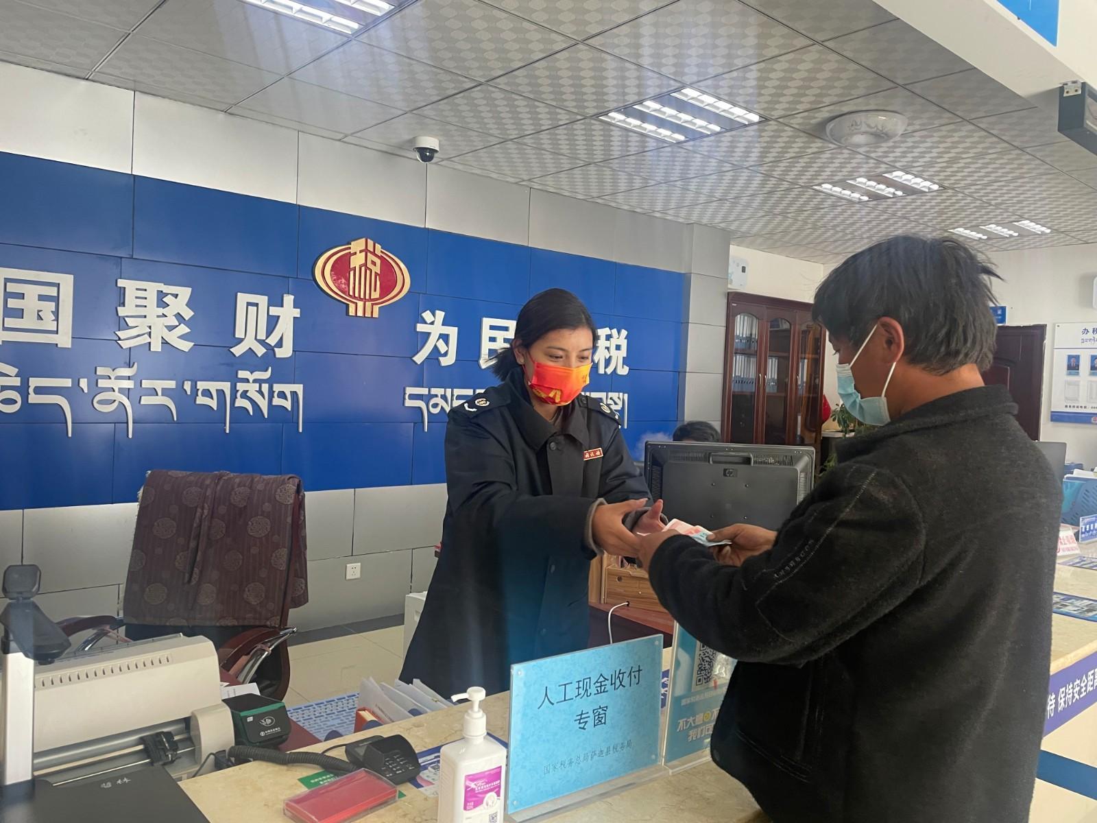 圖為薩迦縣稅務干部提供現(xiàn)金繳費服務.jpg