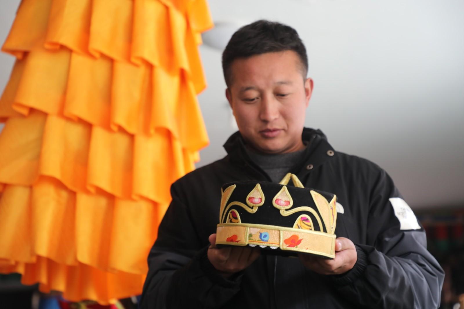 氆氌這門(mén)古老的技藝不僅是裝點(diǎn)藏族百姓生活的“潮品”，還是當(dāng)?shù)厝罕娫鍪罩赂坏暮脦褪?。該合作社已?jīng)帶動(dòng)了村里15家貧困戶就業(yè)脫貧，現(xiàn)有12人在此就業(yè)，每年還額外給村里分紅將近5萬(wàn)元。2021年，合作社又在二樓加蓋了婦女綜合活動(dòng)室，用于開(kāi)展各類學(xué)習(xí)活動(dòng)。圖為顧客在合作社購(gòu)買(mǎi)帽子。