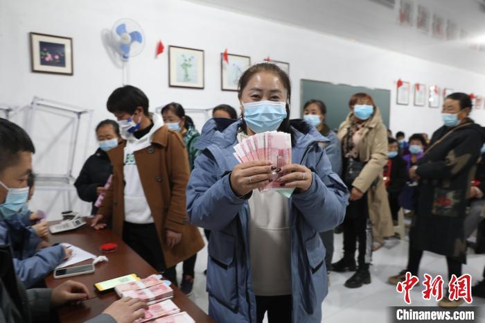 圖為肖主拉領(lǐng)到了“工資”?！】朴抑衅煨麄鞑抗﹫D