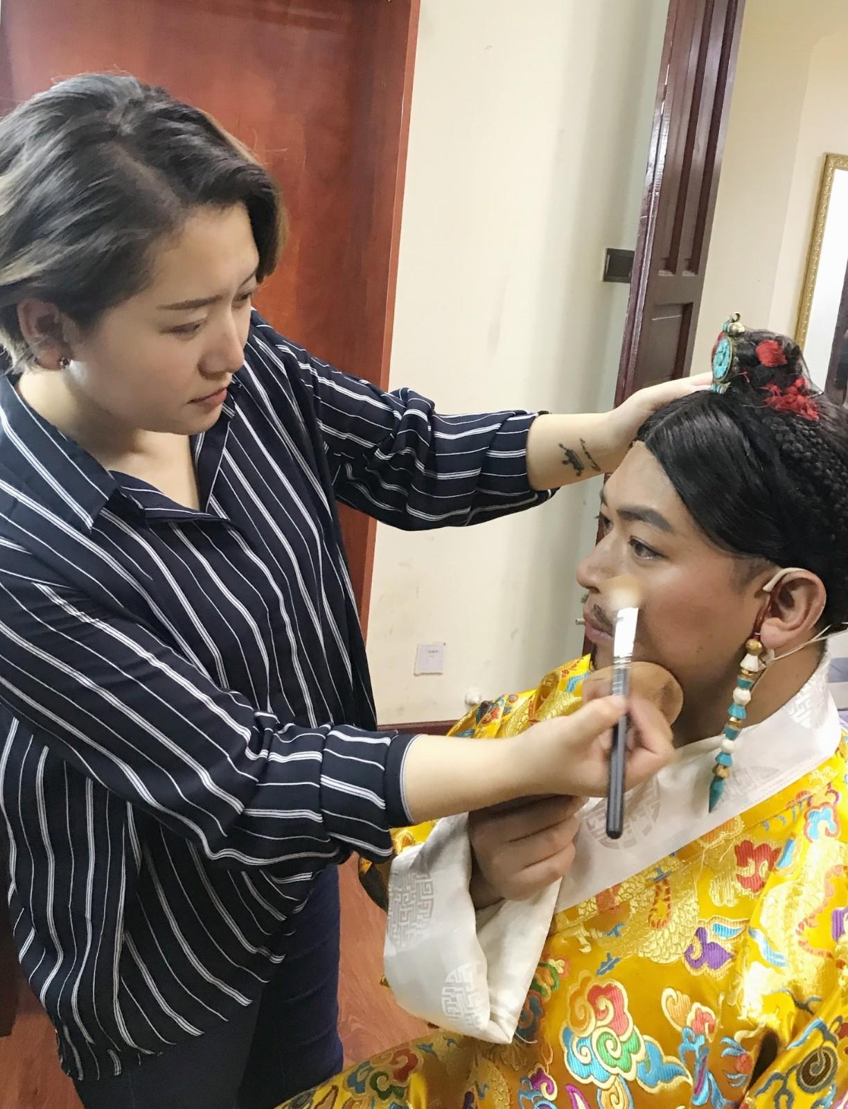 從小就生活在自治區(qū)藏劇團的家屬區(qū)，德珍對臺前幕后的流程都熟稔于心，特別是看到母親為演員們定妝造型、挑選服裝，愛美的種子就在她的心中生根發(fā)芽，那個時候她就暗下決心要干這一行。圖為德珍為藏歷新年晚會演員、工作人員化妝。