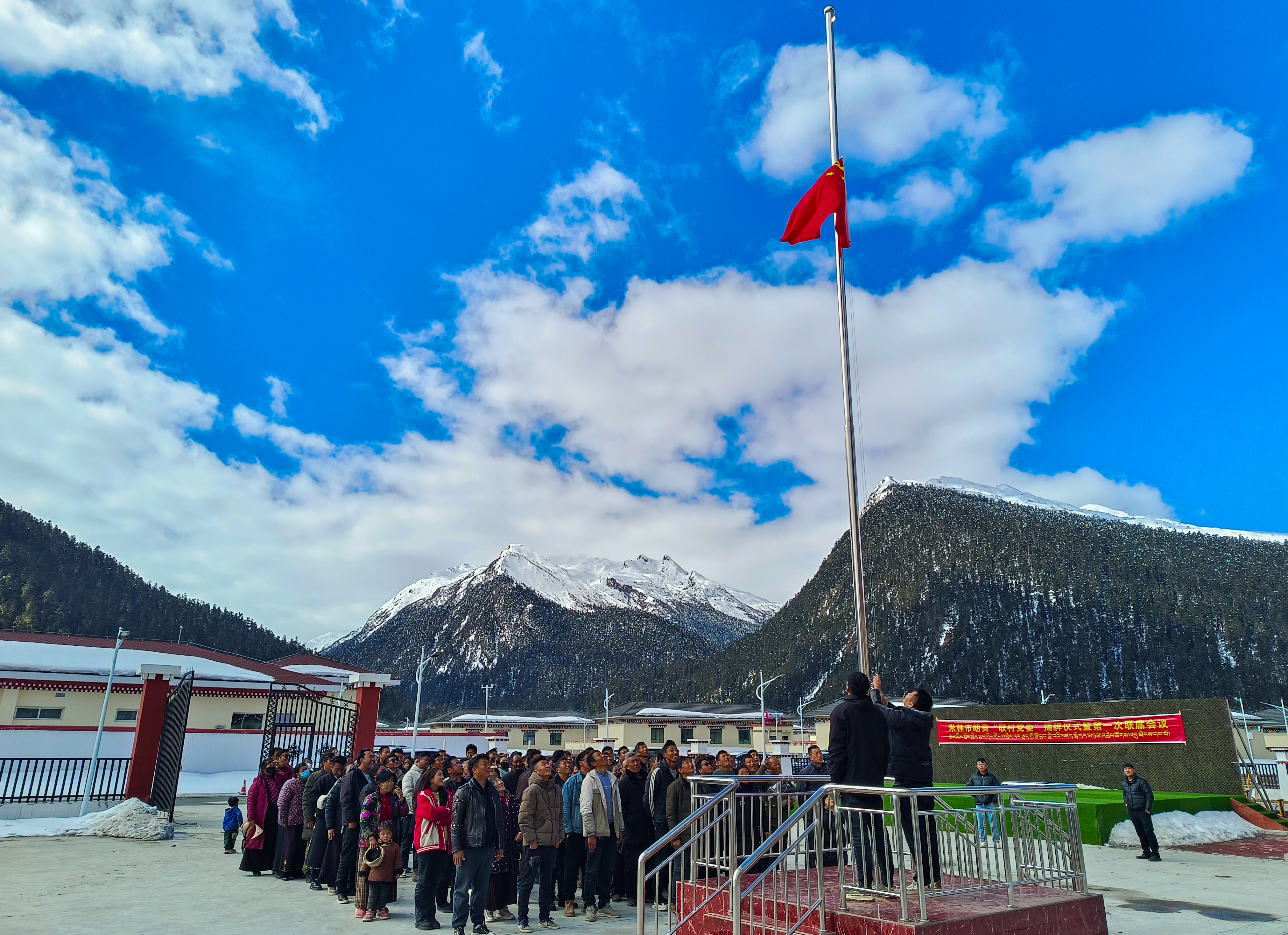 圖為3月28日，米林市里龍鄉(xiāng)才巴村朗貢搬遷點(diǎn)的群眾舉行紀(jì)念西藏百萬農(nóng)奴解放65周年升國旗儀式。周宇 記者 丹增群培 攝