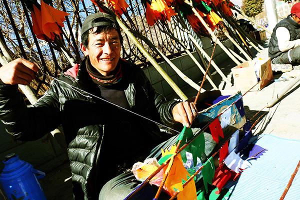圖為：1月23日上午，來(lái)自西藏日喀則市南木林縣農(nóng)民旦增平措，在藏歷火雞新年前來(lái)山南縫制、銷(xiāo)售經(jīng)幡樹(shù)。他說(shuō)，每天可以賣(mài)出30棵左右，每棵平均賣(mài)300元至150元不等，收入可觀。曲杰 攝.jpg